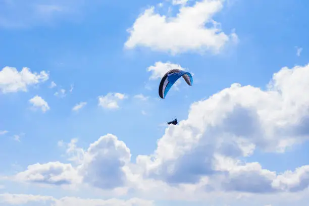 Photo of man on a parachute flying in the clear sky