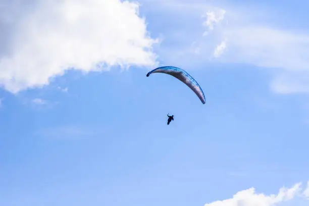 Photo of man on a parachute flying in the clear sky