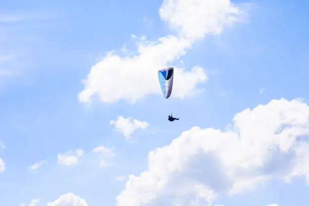 Photo of man on a parachute flying in the clear sky