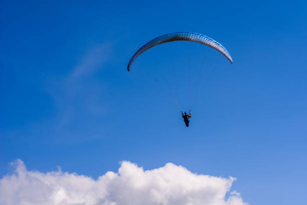 istock man on a parachute flying in the clear sky 641439478