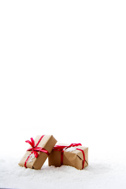 Christmas presents in brown paper with red ribbon stock photo