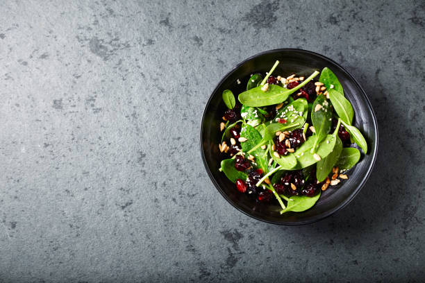 салат из шпината с сушеной клюквой и семенами граната - cranberry salad стоковые фото и изображения