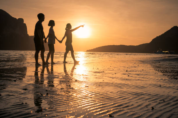 istock happy family walking on the beach 641445098