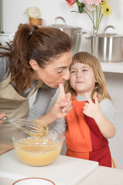 istock funny mother and child tasting whipped cream with finger 641448498