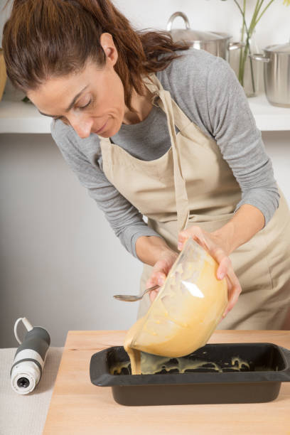istock woman pouring cream into baking loaf 641448610