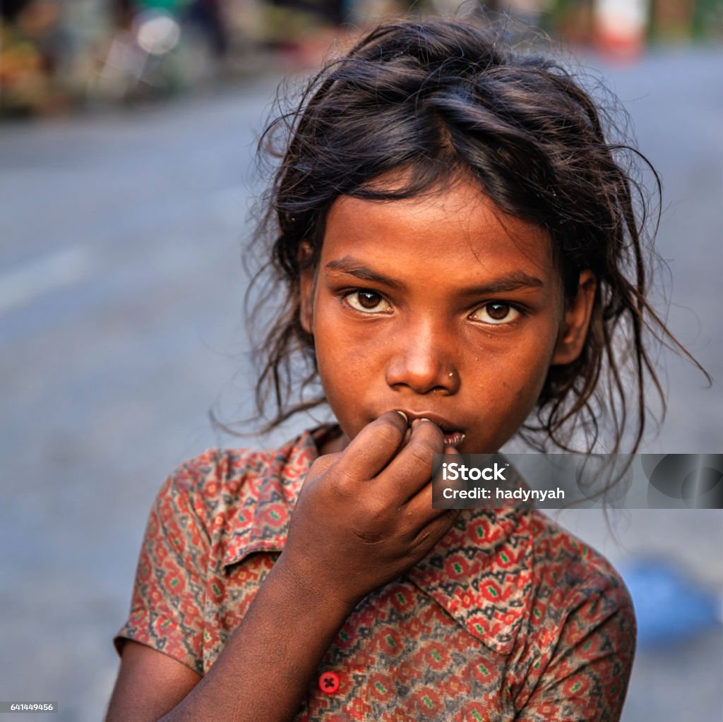 Poor Indian girl asking for help Poor Indian girl asking for support. Many Indian children suffer from poverty - more than 50% of India's total population lives below the poverty line, and more than 40% of this population are children. Poverty Stock Photo