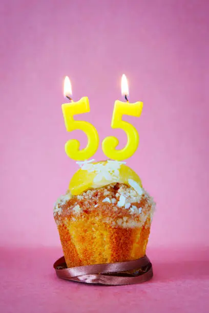 Photo of Muffin with burning birthday candles as number fifty five