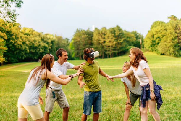 istock Group of friends enjoying nature and trying virtual reality simulator 641454328