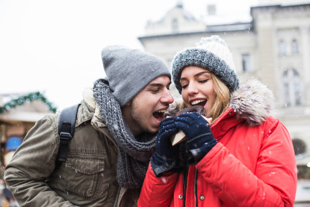 istock Couple sharing chocolate donut at Christmas market 641455104