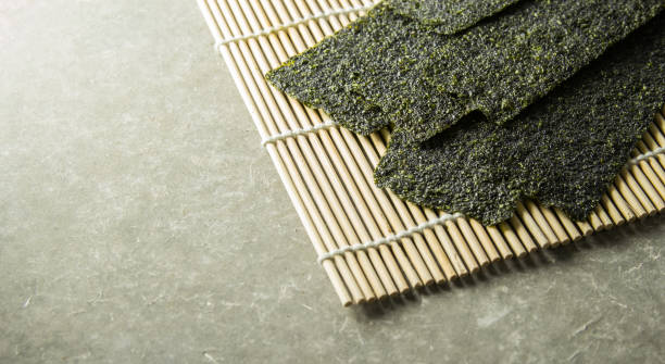 Seaweed roasted  snack (nori) on mat. Seaweed roasted  snack (nori) on Japanese traditional bamboo mat. nori stock pictures, royalty-free photos & images