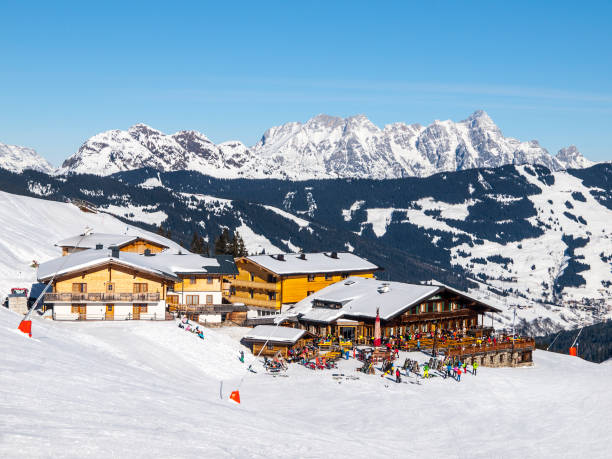 descente de pente et apres refuge de montagne de ski avec terrasse de restaurant à saalbach hinterglemm leogang winter resort, tirol, autriche, europe. journée ensoleillée tournée - apres ski photos photos et images de collection