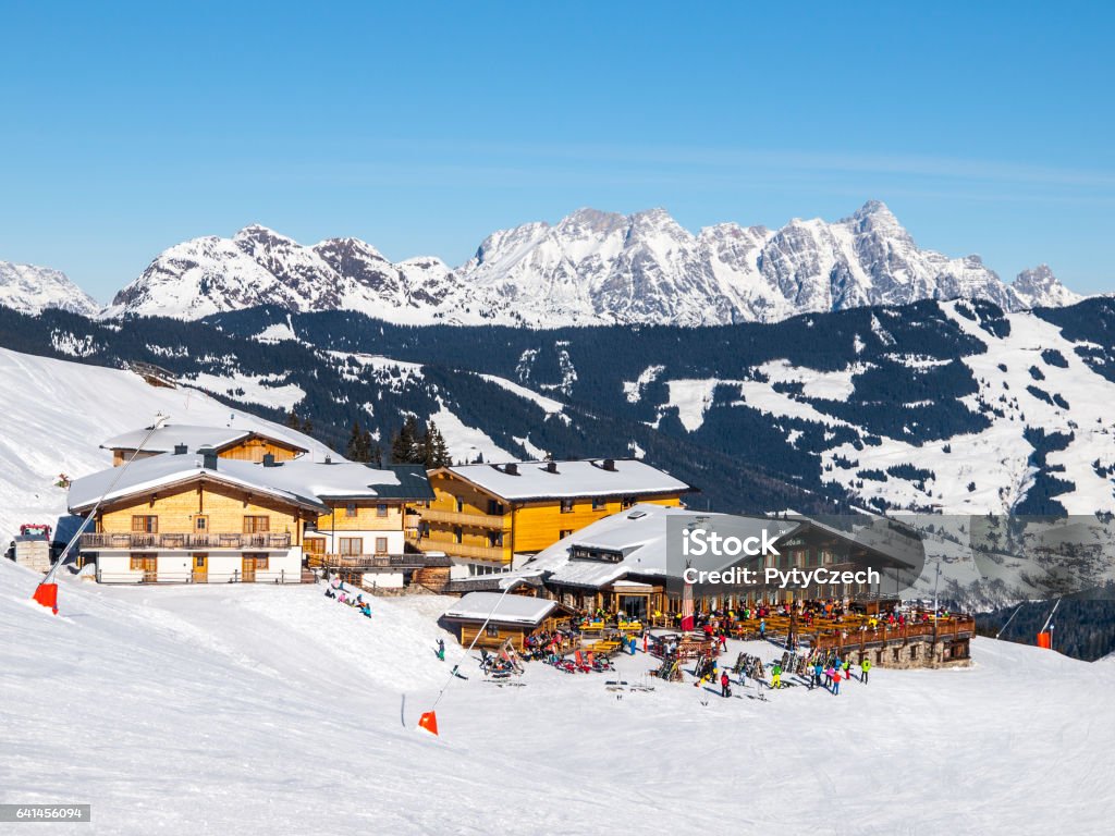 Downhill slope and apres ski mountain hut with restaurant terrace in Saalbach Hinterglemm Leogang winter resort, Tirol, Austria, Europe. Sunny day shot Downhill slope and apres ski mountain hut with restaurant terrace in Saalbach Hinterglemm Leogang winter resort, Tirol, Austria, Europe. Sunny day shot. Saalbach Stock Photo