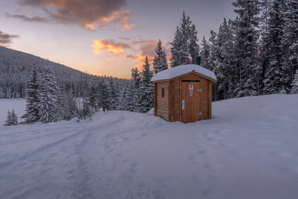 Winter Outhouse on Frozen Mountain Lake winter outdoor toilet on the banks of Two Jack Lake in Banff National Park, Canada Outhouse stock pictures, royalty-free photos & images