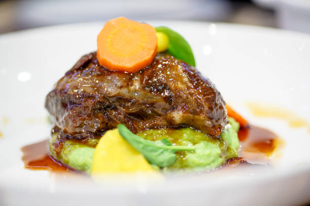 istock Braised beef with carrots lying on a green mashed potatoes with wasabi. 641459836