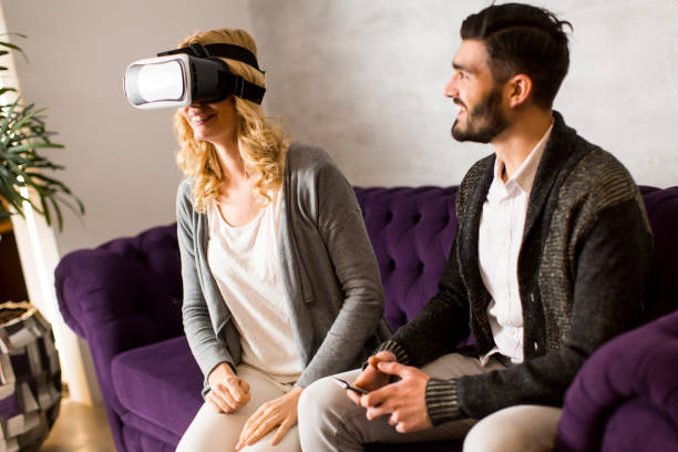 istock Young couple sitting in the room with virtual reality glasses 641463580