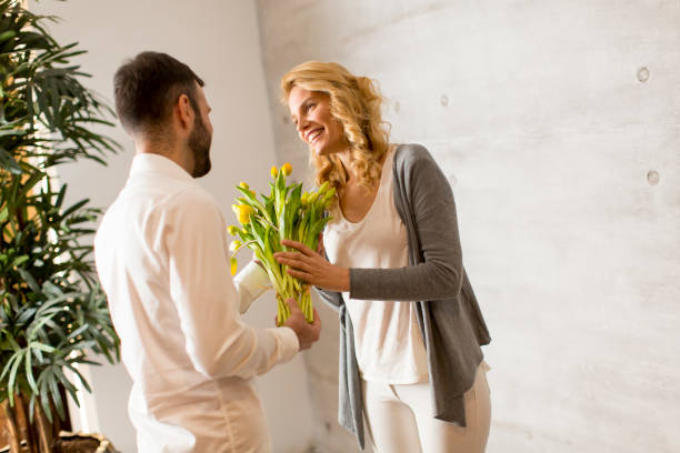 istock Young couple with yellow tulips bouquet 641464158