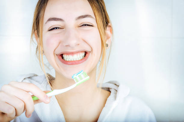mulher jovem feliz, escovar os dentes. - brushing teeth human teeth women cleaning - fotografias e filmes do acervo