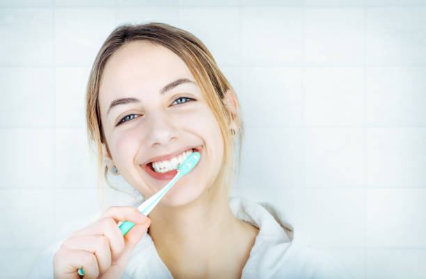 giovane donna felice che si lava i denti. - healthy lifestyle toothbrush caucasian one person foto e immagini stock