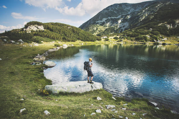 Traveler standing at the lake in mountains