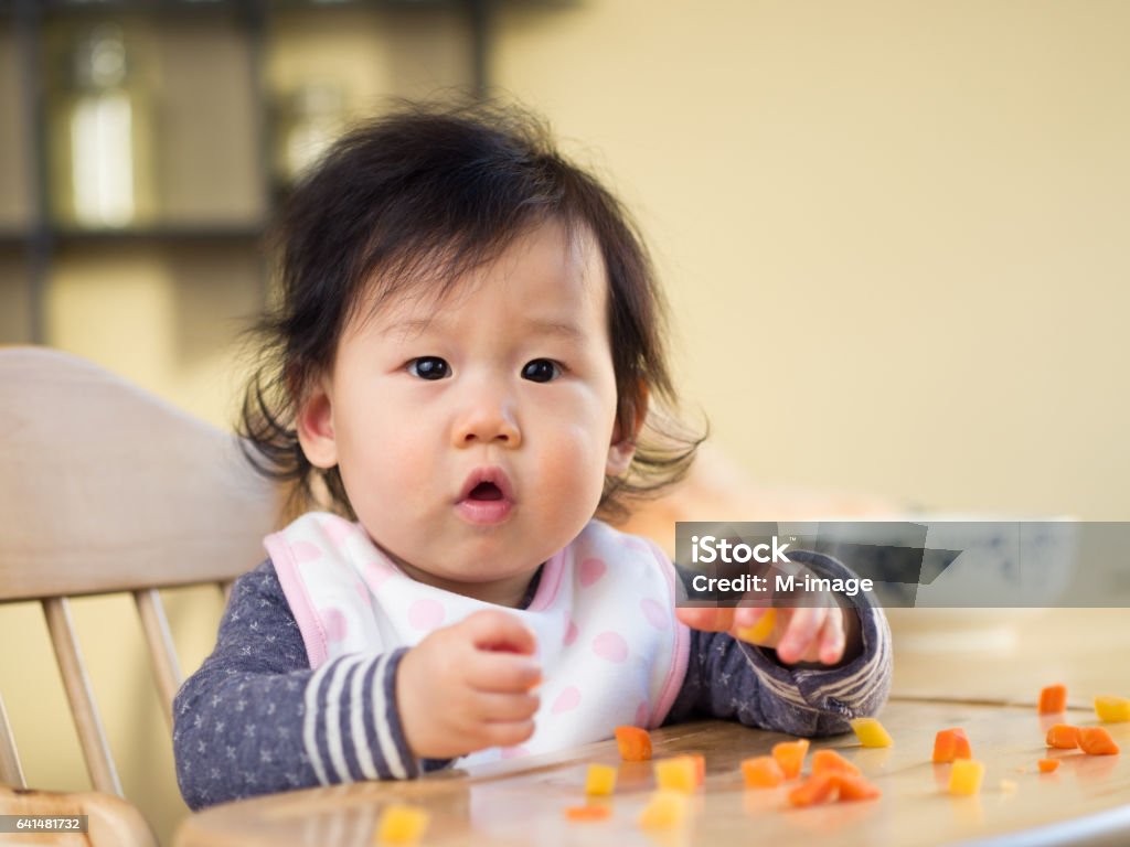 niña comiendo vegetales primera vez - Foto de stock de Bebé libre de derechos