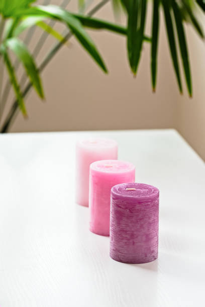 istock Three pink ombre scented candles on white table 641482402