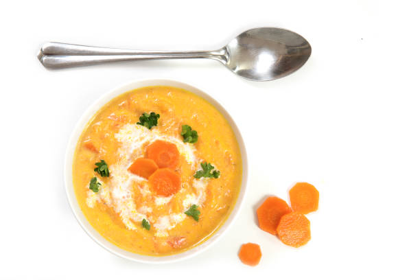 морковный суп и ложка сверху, изолированные на белом - carrot isolated white carotene стоковые фото и изображения