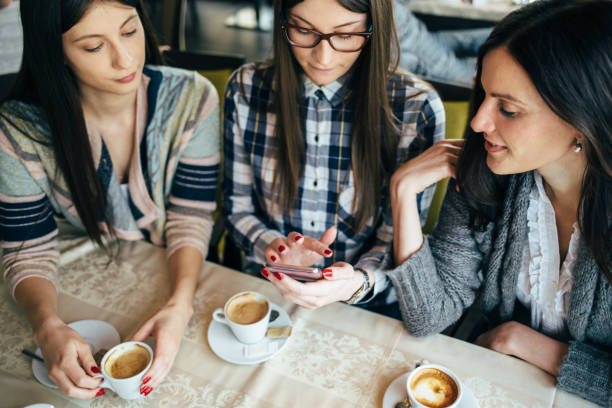 istock Three young female friends looking at smart phone 641486780