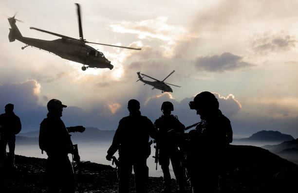 Military Mission at dusk Silhouette of soldiers and helicopters during a military mission at dusk. us air force photos stock pictures, royalty-free photos & images