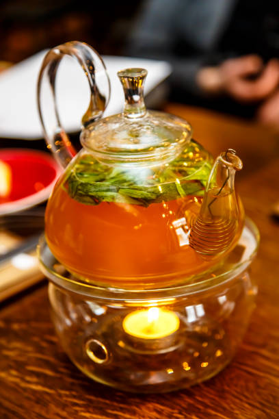 istock Tea in a glass teapot on a stand with a candle. 641491044