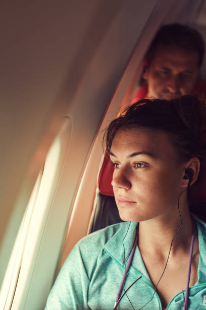 istock Young woman in plane sitting by the window 641493234