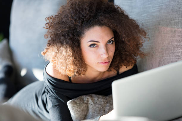 istock Beautiful woman on couch with laptop 641493898