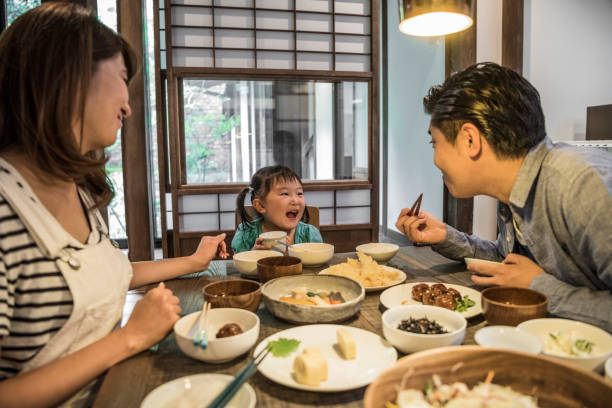 istock Japanese family sitting at dining table eating dinner 641499388