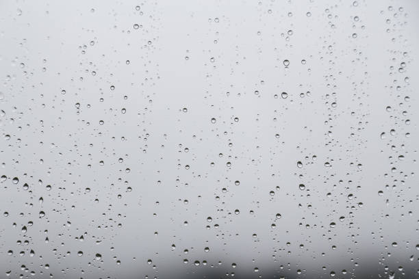istock Rain water droplets on glass window with gloomy sky 641500106