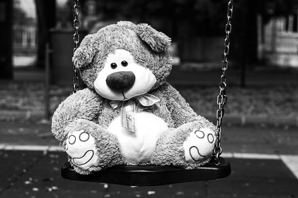 istock Depressed Fluffy Soft Cute Teddy Bear Toy sitting cradle park 641501626