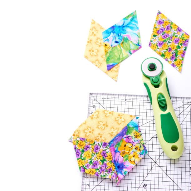 istock Pieces of quilt with rotary knife and ruler on white surface, top view 641502152