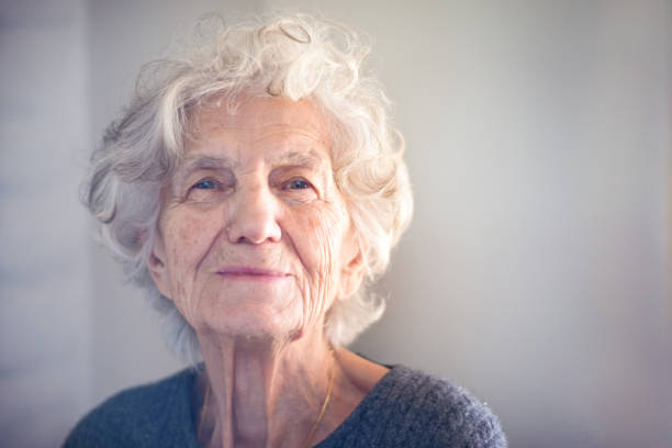 senior femenino con suave sonrisa - one old woman only fotografías e imágenes de stock