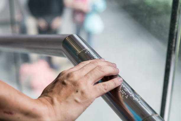 istock Hand reading Braille for the blind on public amenity railing 641515264