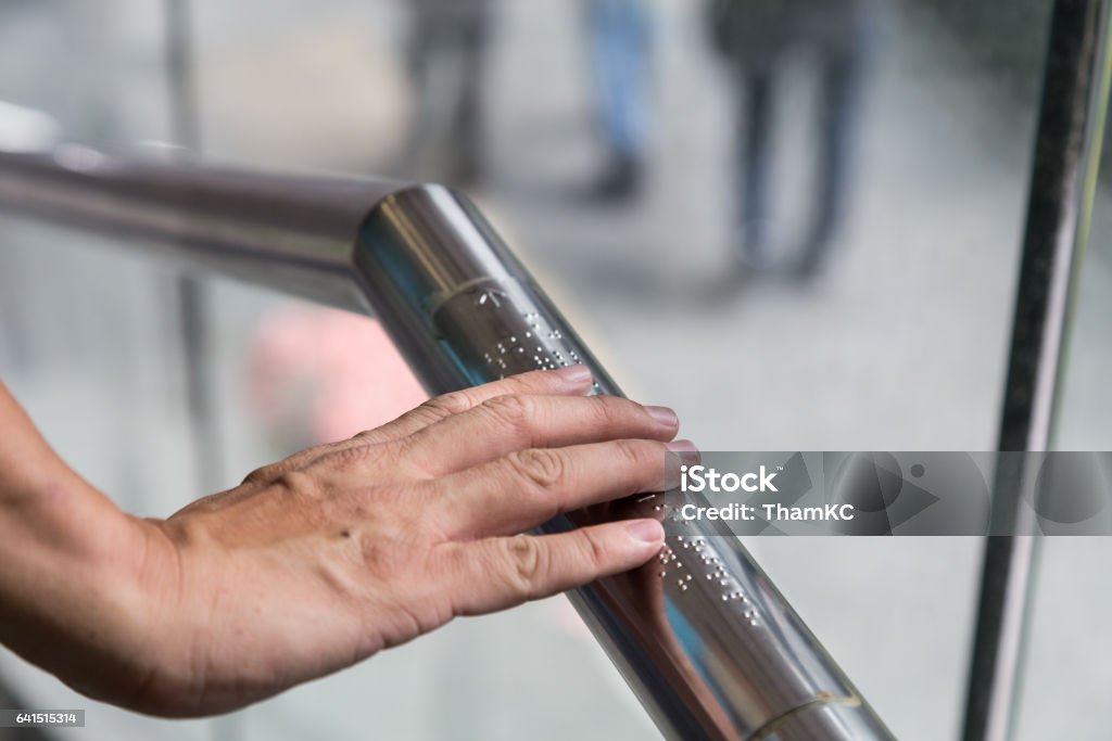 Hand lezen braille voor blinden op openbare voorziening reling - Royalty-free Braille Stockfoto