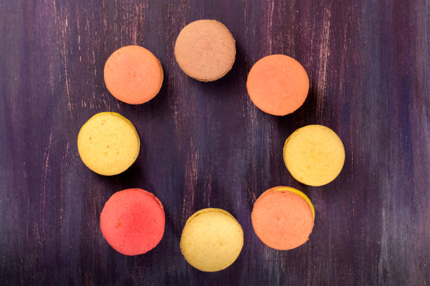 Macarons forming frame on vibrant purple texture