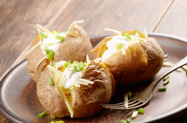 Baked Potatoes Baked Potato with chives, cheese, and sour cream baked potato sour cream stock pictures, royalty-free photos & images