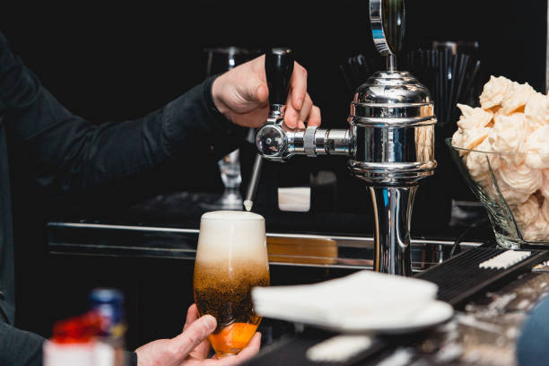 istock bartender pours a glass of light beer 641524928