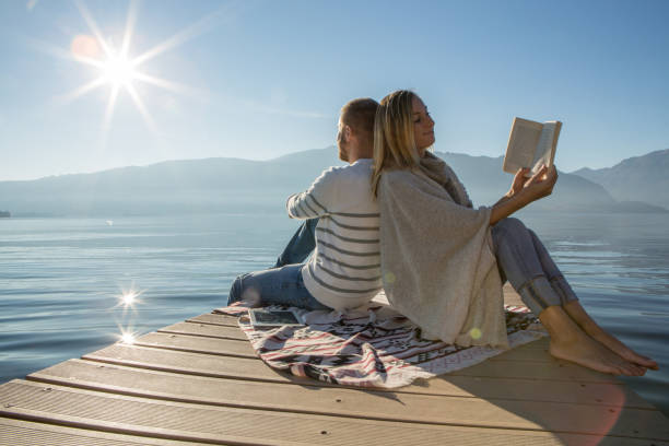 istock Young couple relaxing on lake pier 641528198