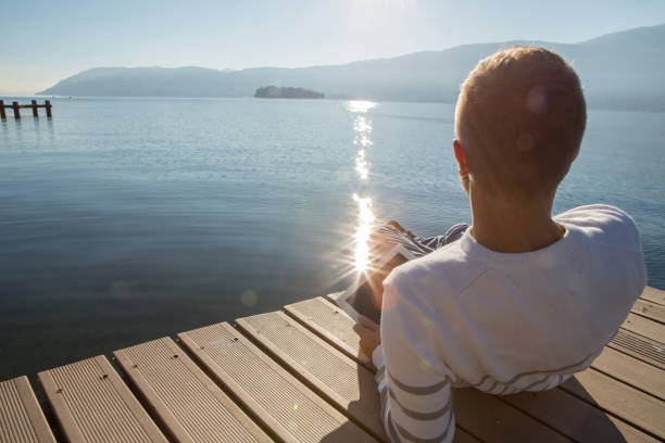 istock Young man relaxing on lake pier with digital tablet 641528488
