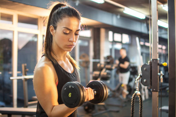 istock Athletic young lady doing workout with weights in gym. 641529156