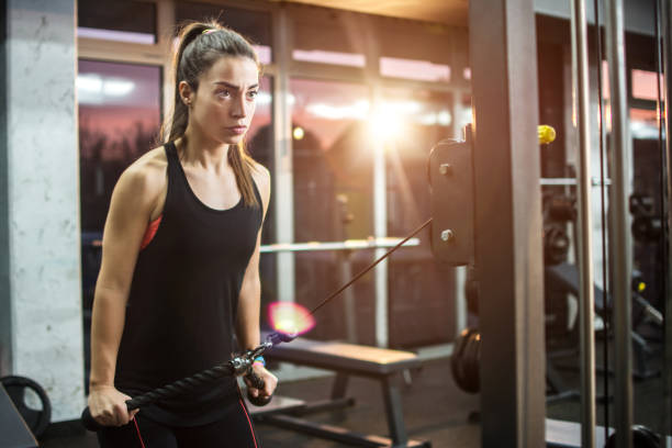 istock Young sporty girl working out on pull-down machine in gym. 641529254