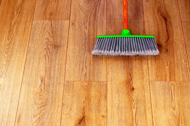 istock cleaning wooden floor with green plastic broom 641530052