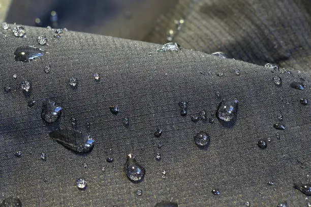 detail of fabric water repellent, close up on an outdoor jacket material with water drops