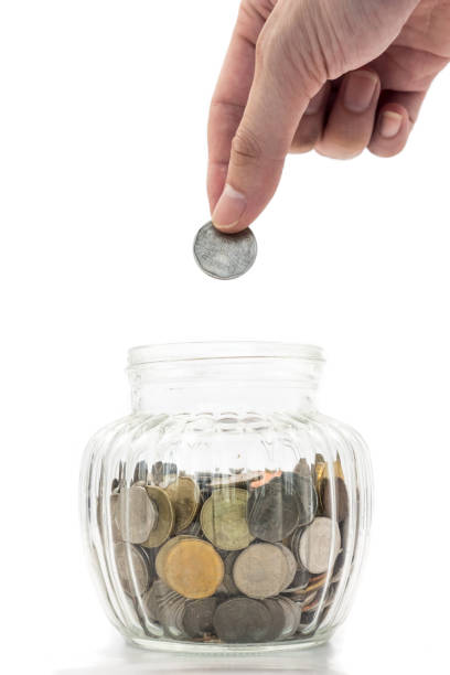istock Hand putting a coin into glass bottle on white background, future saving concept 641533266