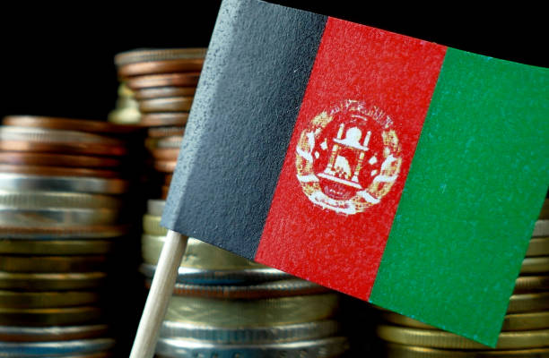 afghanistan-fähnchen mit stapel von geld münzen makro - support horizontal war afghanistan stock-fotos und bilder
