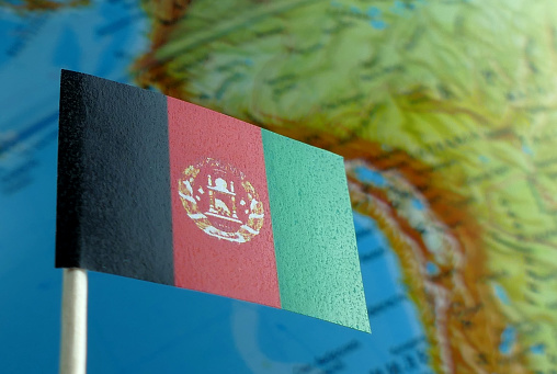 Afghanistan flag with a globe map as a background macro